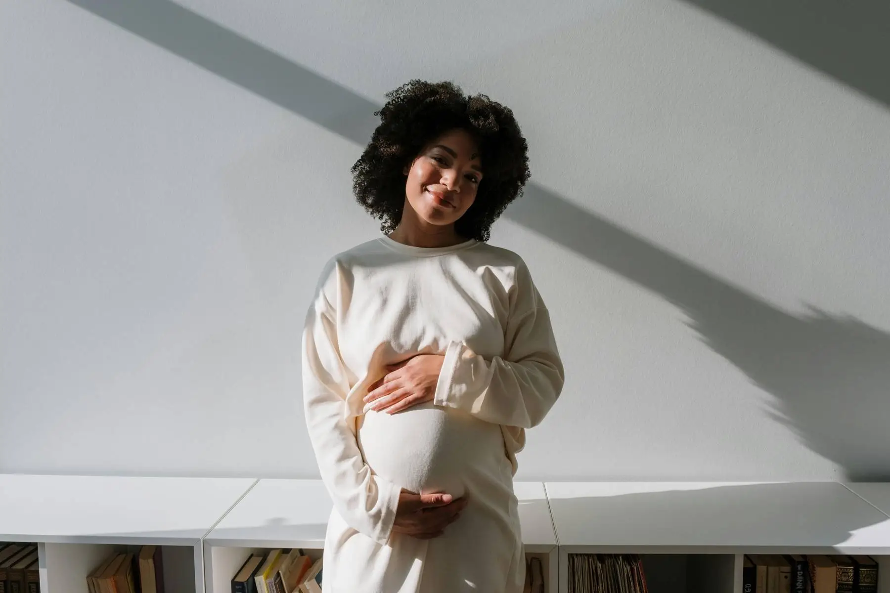 Pregnant surrogate standing in sunlight, representing EDSI’s California surrogacy process for intended parents
