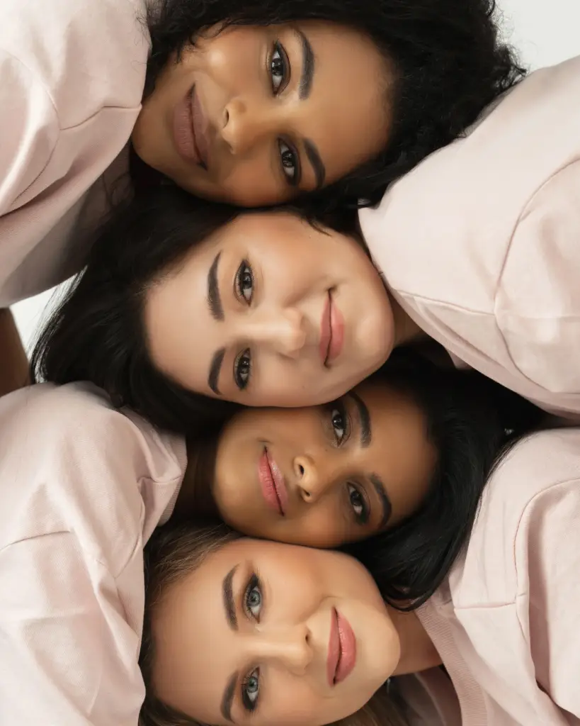 Four diverse women lying together in unity, symbolizing connection and compatibility through EDSI’s Matching Compass™