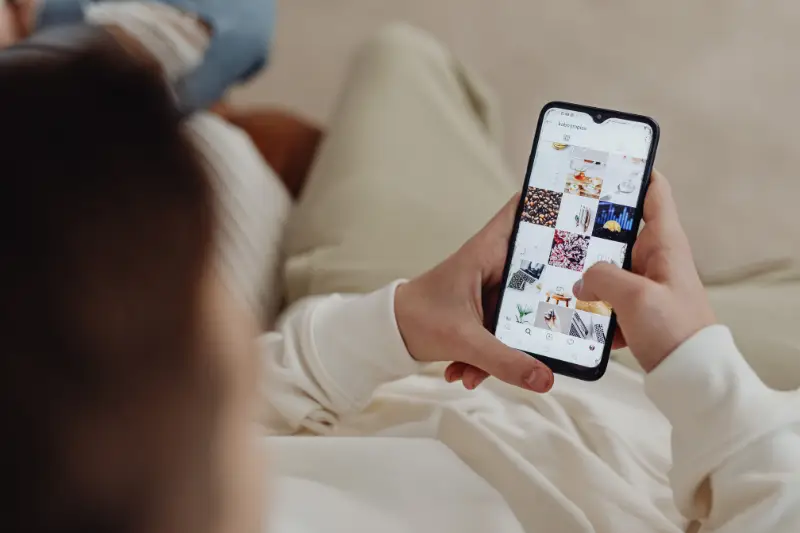 Person browsing Instagram feed on a smartphone, exploring visual posts related to lifestyle and discovery