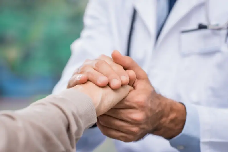 Doctor holding patient’s hand at a fertility clinic, symbolizing care and trust in top fertility clinics in the U.S.