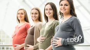 Becoming a surrogate at EDSI. Four pregnant women standing indoors and smiling, representing supportive surrogate care.