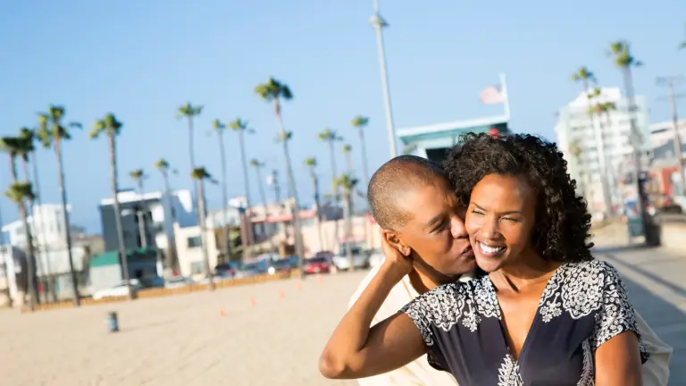 Intended parents smiling together on a California beach representing trust and happiness with EDSI surrogacy services