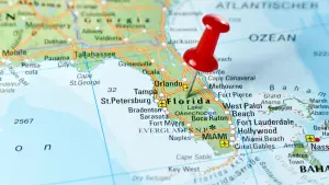 Map of Florida with a red pin marking the state used in an article about becoming a surrogate in Florida with Egg Donor and Surrogacy Institute EDSI