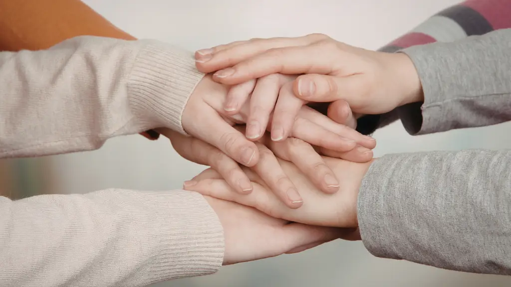 people placing hands together showing support and teamwork in a surrogacy journey